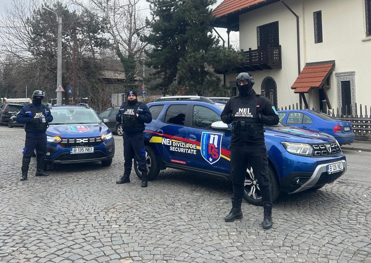 Echipaj de intervenție NEI lângă două autovehicule Dacia cu însemnele companiei